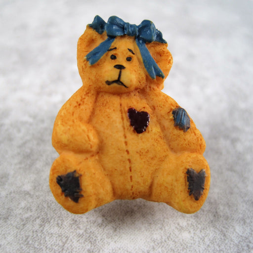 A tan bear with hair bow.
