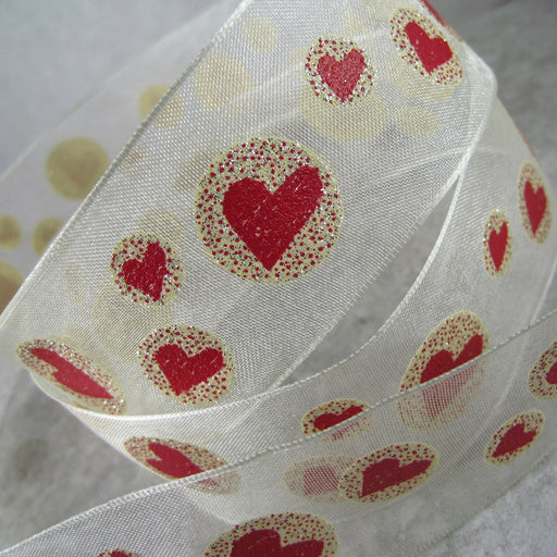 Sheer, bridal white, wired ribbon, with a cream and red, heart motif. 38mm.