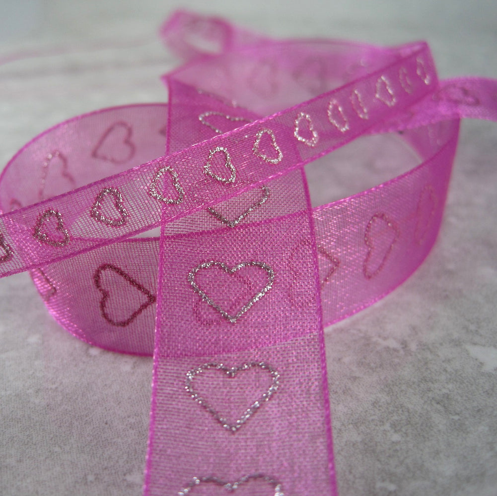 Sheer magenta ribbon, with a sparkly, silver, heart shaped motif